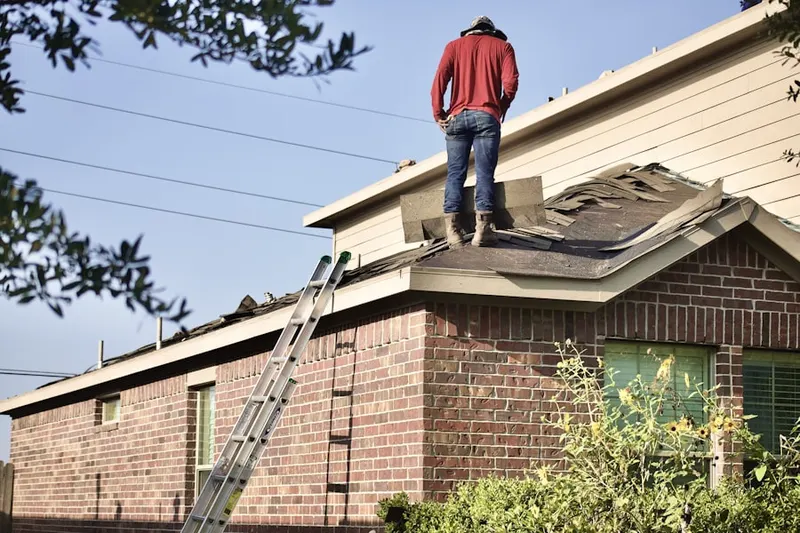 Professional roofer working on a residential roof in Kangley